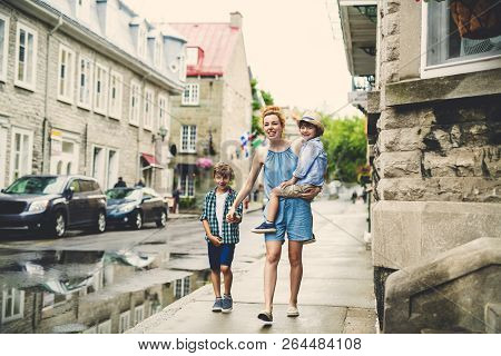 Mother With Her Two Son Outside In An Urban Street