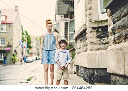 Mother With Her Son Outside In An Urban Street
