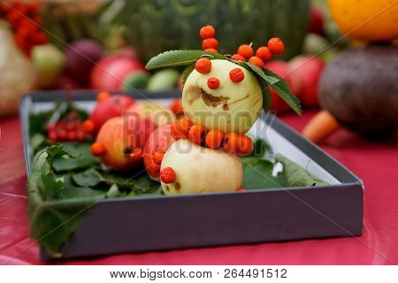 Cheerful Snowman With Apples And Ashberry. An Example Of Decorative Work With Vegetables. Autumn Har
