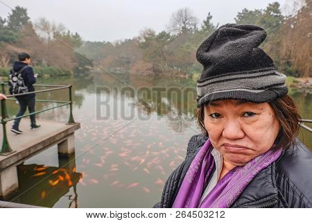 Happy Old Asian Women Traveler Make A Funny Face In The Xihu Lake(west Lake) Park In Hangzhou China