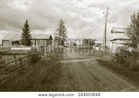 Dirt Road And Old Wooden Houses In Northern Russian Village Nermusha, Arkhangelsk Region, Russia. Mo