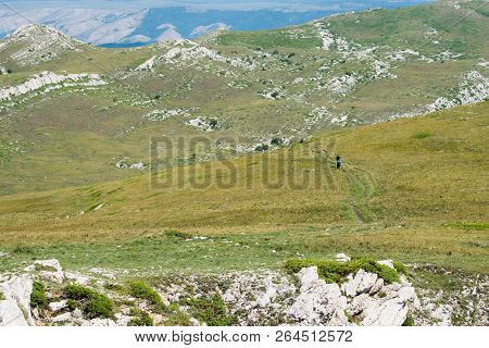 Mountanious Scenic Empty Landscape With Walking Tourists.