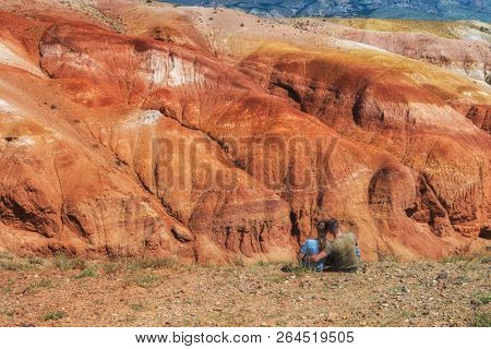 Relaxing man and woman in Valley of Mars landscapes in the Altai Mountains, Kyzyl Chin, Siberia, Russia
