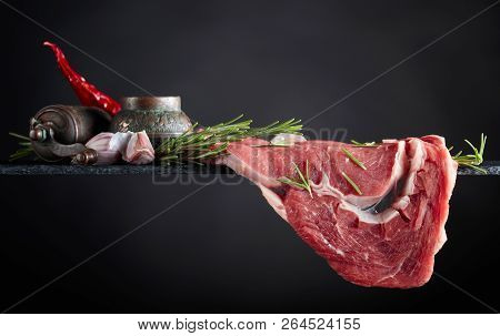 Raw Beef Steak With Peppermill, Garlic And Rosemary.