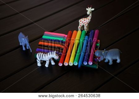 African Animals With Curiosity Look At The Multi-colored Felt-tip Pens. Didactic Material.