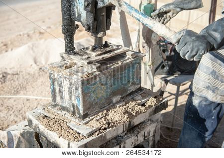 mMan making brick from concrete mix