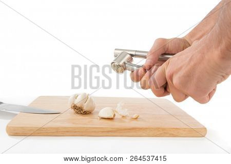 Male hand pressing garlic masher isolated on white background. 