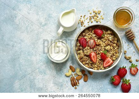 Multicereal Homemade Organic Granola Served With Fresh Strawberry, Nuts, Honey, Milk And Yogurt.top