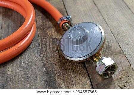 Regulator For Propane-butane Gas Cylinder And Accessories On A Wooden Workshop Table. Gas Accessorie