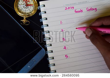 Notebook, Smartphone, Compass And Pen, With Selective Focus 2019 Goals Setting Text In Someone Hand 
