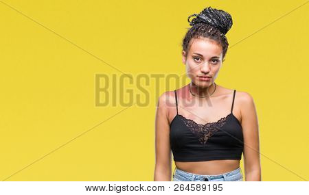 Young braided hair african american with pigmentation blemish birth mark over isolated background with serious expression on face. Simple and natural looking at the camera.