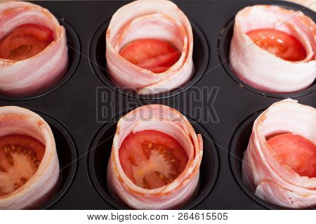 Cooking Delicious Bacon Egg Muffins. View Of Bread Circles With Tomato Slices Wrapped In Bacon In No