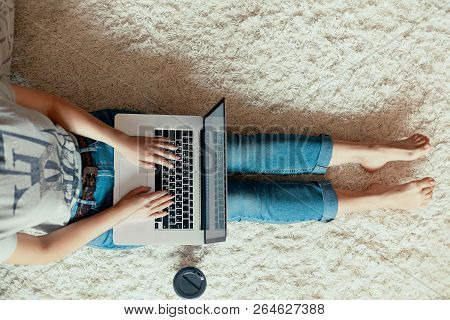 Top View Of Young Woman Sitting On Floor With Laptop