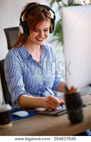 Young graphic designer working in office at desk 