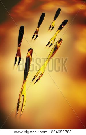 Muliple Dessert Forks On A Warm Background