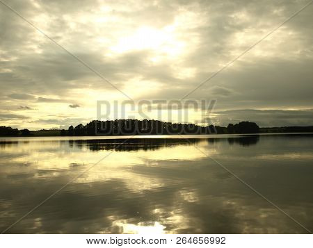Yellow Sunset Over The Lake And Clouds