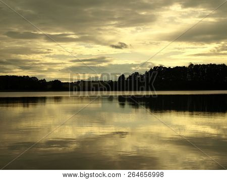 Yellow Sunset Over The Lake And Clouds