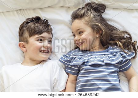 Brother And Sister Having Fun Together On Bed