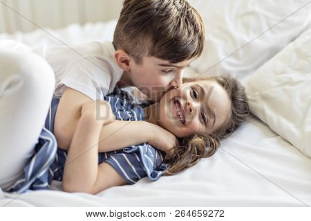 Brother And Sister Having Fun Together On Bed