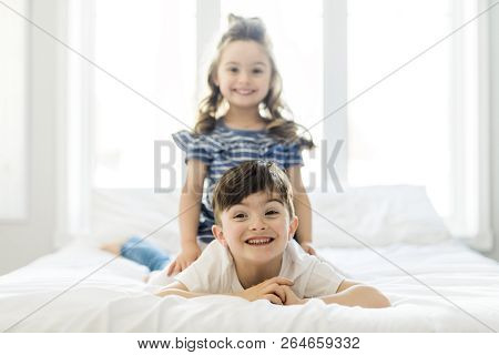 Brother And Sister Having Fun Together On Bed