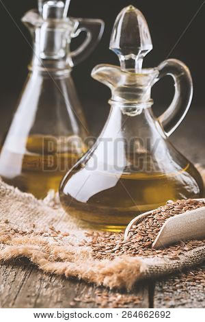 Flax Seeds And Linseed Oil In A Glass Jug On A Wooden Table, Healthy Diet With Omega 3 Fatty Acids