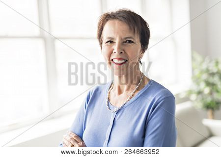 Happy Joyful Senior Lady In Front Of A Window