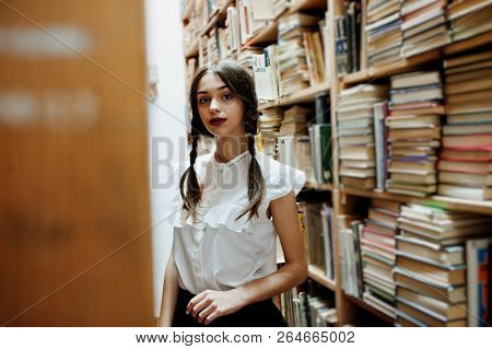 Girl With Pigtails In White Blouse At Old Library.