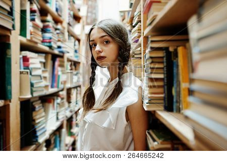 Girl With Pigtails In White Blouse At Old Library.