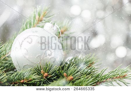 Silver Christmas Background Of Defocused Bokeh Lights With Decorated Fir Tree Branches