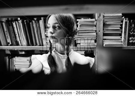 Girl With Pigtails In White Blouse At Old Library.