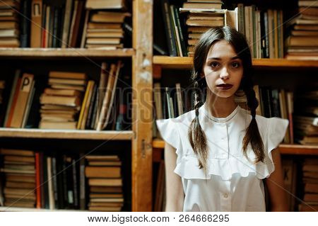 Girl With Pigtails In White Blouse At Old Library.
