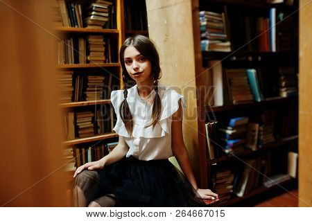 Girl With Pigtails In White Blouse At Old Library.