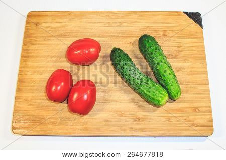 Vegetables Cucumbers Tomatoes On A Wooden Board