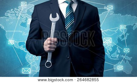 Businessman holding tool with global map graphic on the background