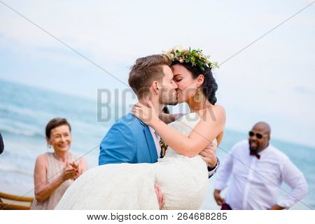 Cheerful newlyweds at beach wedding ceremnoy