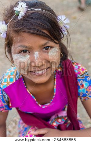 MANDALAY, MYANMAR - MARCH 12 : Unidentified Burmese girl with traditional thanaka on her face on March 12, 2016 in Mandalay, Myanmar.Thanaka is a yellowish-white cosmetic paste made from ground bark