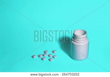 Assorted Pharmaceutical Medicine Pills, Tablets And Capsules And Bottle On Blue Background. Space Fo