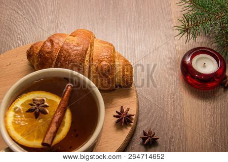 A Cup Of Hot Delicious Tea With A Croissant On A Wooden Platform With A New Years Decor In The Form 