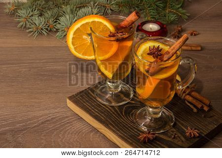 Two Glasses With Delicious Fragrant Tea Of Mulled Wine With Orange And Spices On A Wooden Board With