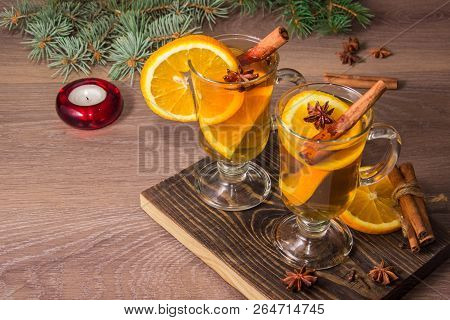 Two Glasses With Delicious Fragrant Tea Of Mulled Wine With Orange And Spices On A Wooden Board With