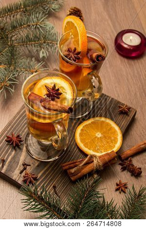 Two Glasses With Delicious Fragrant Tea Of Mulled Wine With Orange And Spices On A Wooden Board With