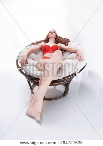 Beautiful Woman In Red Underwear Relaxing In A Round Chair Papasan .photo With Copy Space