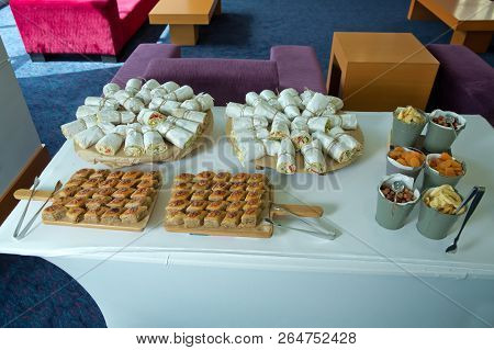 Business And Entrepreneurship. The Waitress Filed A Glass Of White Coffee With The Sausage Between T
