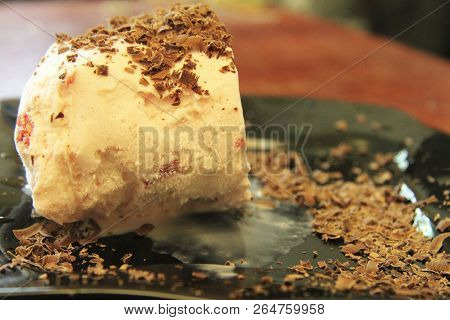 Chocolate Ice Cream And Hardered Chocolate Over Eady For Eat On The Black Plate