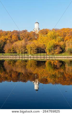 Colorful Autumn. Alley Along The Riverbank On The Background Of The Autumn Park. Reflections In The 