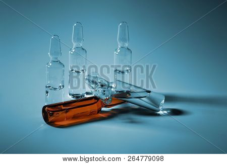 Various Ampulas With Medicine On Blue Background