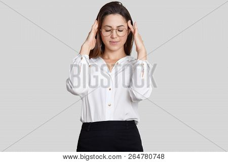 Pretty Young Female Teacher Wears Formal Clothes, Keeps Hands On Temples, Suffers From Headache Afte