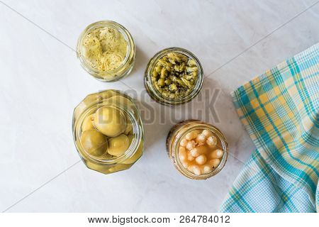 Jars Of Pickled Vegetables Green And White Asparagus, Artichoke Heart And Unripe Green Almond Pickle