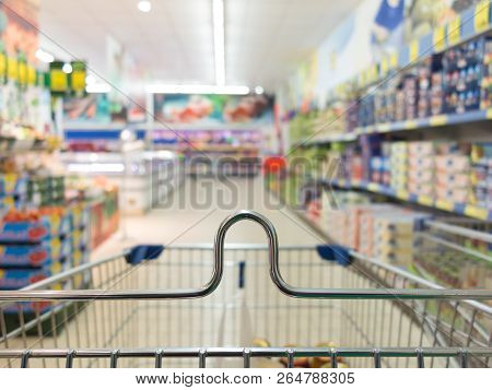 View From Shopping Cart Trolley Basket At Supermarket Self-service Grocery Shop. Retail. Blurred Bac