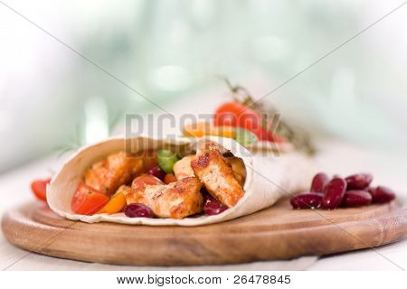 Delicious mexican wrap with chicken stripes and vegetable
